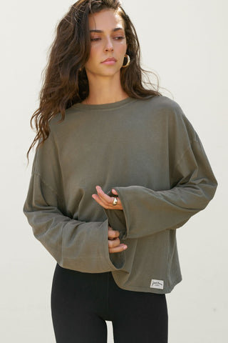 Front view of model posing in the relaxed fit, lightweight olive classic cotton Boxy Crew Long Sleeve top with a crew neckline, dropped shoulders and oversized silhouette