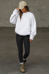 Full body front view of model posing in the soft oversized pearl grey french terry Classic Crew Pullover sweatshirt with a crew neckline and joah brown logo patch sewn on the upper left chest