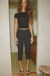 Full body front view of model posing in the lightweight and fitted black modal Classic Crew Tee shirt with a classic crew neckline and short sleeves.