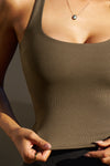 Close up detail front view of model posing in the woodland flexrib Classic Racerback Tank with a scoop neckine and racerback silhouette. 