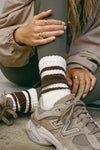 Close up detail front view of model posing in the crew style ribbed soft tobacco Classic Stripe Sock 