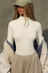 Front view of model posing in the form-fitting and stretchy bone rib Classic Turtleneck long sleeve top