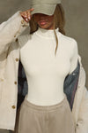Front view of model posing in the form-fitting and stretchy bone rib Classic Turtleneck long sleeve top