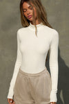 Front view of model posing in the form-fitting and stretchy bone rib Classic Turtleneck long sleeve top
