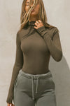 Front view of model posing in the form-fitting and stretchy woodland rib Classic Turtleneck long sleeve top