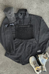 Flat lay view of the charcoal washed rib Square Neck Cami, jet nylon Classic Windbreaker Jacket, jet nylon Classic Track Short, washed black Official Cap and oat and olive Hiker Sock
