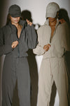 Two models posing in a jet nylon and desert sage nylon Classic Windbreaker Jacket and Barrel Pant sets