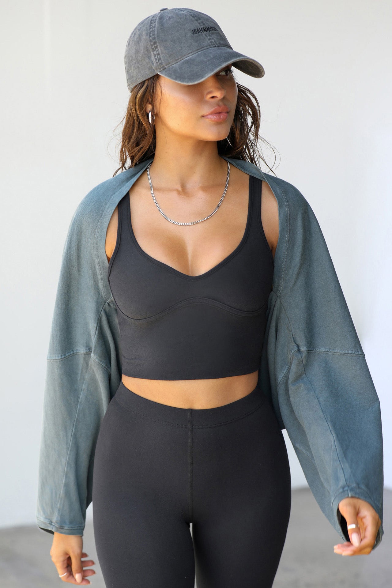 Front view of model posing in the cropped stretchy sueded onyx Contour Crop Tank with a v neckline and shaped seams at the bust