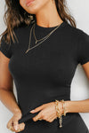 Close up front view of model posing in the form fitting black rib Crewneck Tee with a banded crew neckline and banding at the sleeves