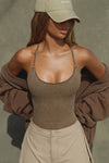 Front view of model posing in the fitted sepia washed rib Cross Back Cami with a scoop neckline and thin adjustable straps that criss cross in the back