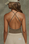 Back view of model posing in the fitted sepia washed rib Cross Back Cami with a scoop neckline and thin adjustable straps that criss cross in the back
