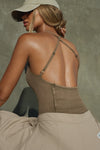 Back view of model posing in the fitted sepia washed rib Cross Back Cami with a scoop neckline and thin adjustable straps that criss cross in the back
