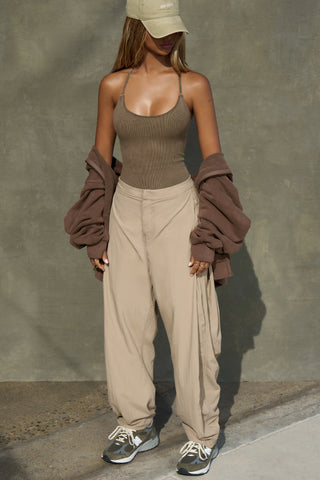 Full body front view of model posing in the fitted sepia washed rib Cross Back Cami with a scoop neckline and thin adjustable straps that criss cross in the back