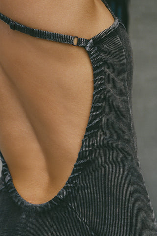 Close up detail back view of model posing in the fitted  charcoal washed rib Cross Back Midi Dress with an asymmetrical hem, a low scoop back and thin adjustable straps that criss cross in the back