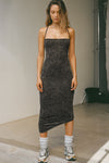 Full body front view of model posing in the fitted  charcoal washed rib Cross Back Midi Dress with an asymmetrical hem, a low scoop back and thin adjustable straps that criss cross in the back