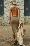 Full body back view of model posing in the fitted  sepia washed rib Cross Back Midi Dress with an asymmetrical hem, a low, scoop back and thin adjustable straps that criss cross in the back