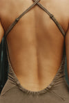 Close up detail back view of model posing in the fitted  sepia washed rib Cross Back Midi Dress with an asymmetrical hem, a low, scoop back and thin adjustable straps that criss cross in the back