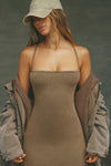 Front view of model posing in the fitted  sepia washed rib Cross Back Midi Dress with an asymmetrical hem, a low, scoop back and thin adjustable straps that criss cross in the back