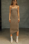 Full body front view of model posing in the fitted  sepia washed rib Cross Back Midi Dress with an asymmetrical hem, a low, scoop back and thin adjustable straps that criss cross in the back