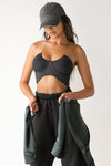 Front view of model posing in the ultra-cropped sueded onyx Curve Scrunch Tank with delicate corded straps, ruched cups at the bust and a curved hem