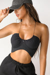 Front view of model posing in the ultra-cropped sueded onyx Curve Scrunch Tank with delicate corded straps, ruched cups at the bust and a curved hem