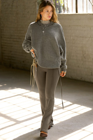 Full body front view of model posing in the fitted, bootcut style sueded carob Cutout Mini Flare Legging with a side keyhole cutout and strappy, self-adjusting ties at the waist
