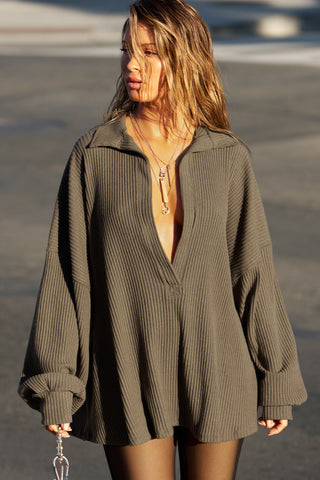Front view of model posing in the street  in the oversized army luxe knit Deep V Pullover with a plunging collared neckline and dropped shoulders