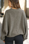 Back view of model posing in the relaxed fit oakmoss sherpa Drop Shoulder Pullover sweatshirt with an exaggerated crew neckline, dropped shoulders and a custom Joah Brown Logo Patch on the left sleeve 