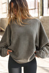 Front view of model posing in the relaxed fit oakmoss sherpa Drop Shoulder Pullover sweatshirt with an exaggerated crew neckline, dropped shoulders and a custom Joah Brown Logo Patch on the left sleeve 