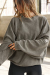 Front view of model posing in the relaxed fit oakmoss sherpa Drop Shoulder Pullover sweatshirt with an exaggerated crew neckline, dropped shoulders and a custom Joah Brown Logo Patch on the left sleeve 
