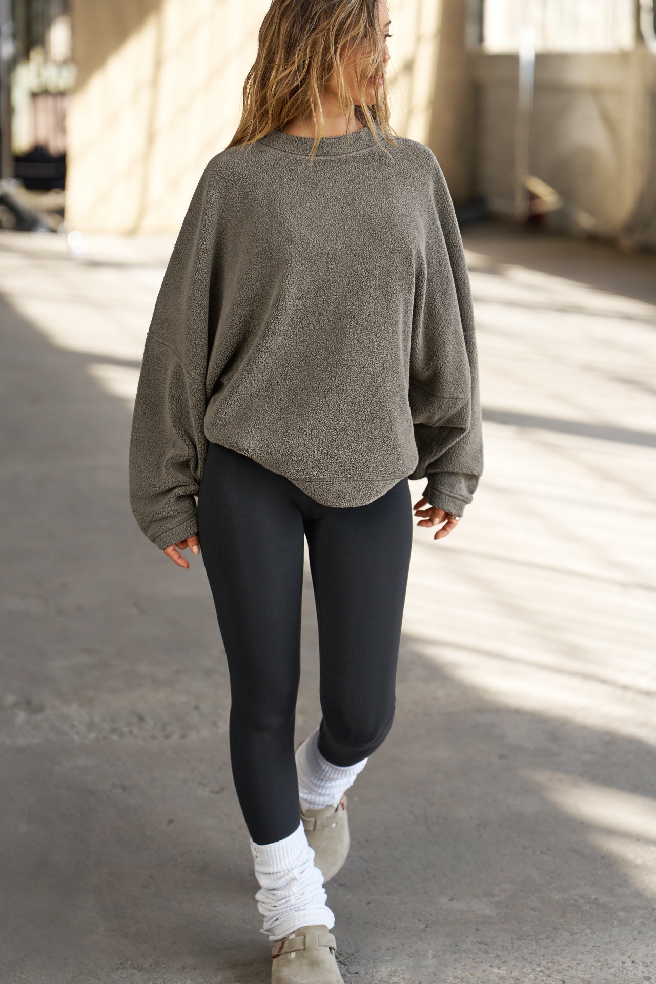 Full body front view of model posing in the relaxed fit oakmoss sherpa Drop Shoulder Pullover sweatshirt with an exaggerated crew neckline, dropped shoulders and a custom Joah Brown Logo Patch on the left sleeve 