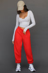 Front view of model posing the oversized loose fit hot sauce french terry Oversized Jogger with an elastic waistband and ankle cuffs