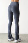 Back view of model from the waist down posing in the full length bootcut sueded navy Second Skin Bootcut Legging with a wide v-shaped waistband and split detail at the leg opening