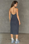 Full body back view of model posing in the stretchy form fitting vintage navy rib Strappy Slit Dress with a high front slit, thin corded straps and a low scoop back that hits at mid-calf