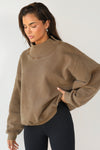 Front view of model wearing the comfortable cocoa french terry Turtleneck Sweatshirt pullover with a side split in the collar and a slightly oversized fit