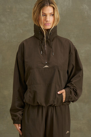 Front view of model posing in the relaxed fit espresso nylon 3/4 Zip Windbreaker jacket with a structured collar and 3/4 zip neckline