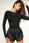 Front view of model posing in the fitted, light weight black modal Boatneck Long Sleeve with a boat neckline