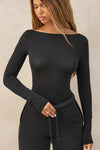 Front view of model posing in the fitted, lightweight black modal Boatneck Long Sleeve with a boat neckline