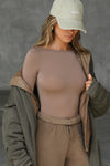 Front view of model posing in the fitted, light weight sienna modal Boatneck Long Sleeve with a boat neckline
