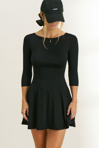 Front view of model posing in the fitted, mini-length black modal Boatneck Mid-Sleeve Dress with a boat neckline, mid-length sleeves and A-line silhoutte 