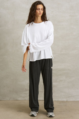 Full body front view of model posing in the relaxed fit, lightweight optic white classic cotton Boxy Crew Long Sleeve top with a crew neckline, dropped shoulders and oversized silhouette