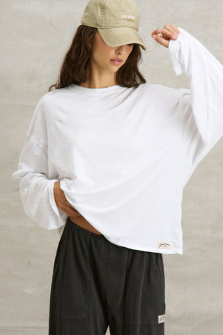Front view of model posing in the relaxed fit, lightweight optic white classic cotton Boxy Crew Long Sleeve top with a crew neckline, dropped shoulders and oversized silhouette