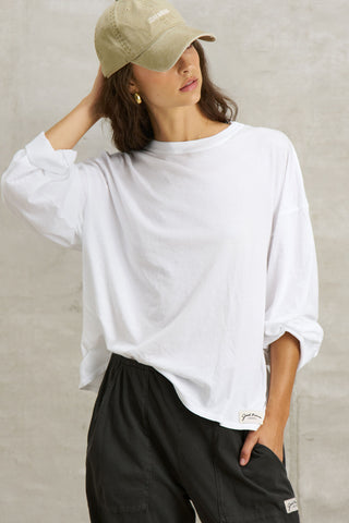 Front view of model posing in the relaxed fit, lightweight optic white classic cotton Boxy Crew Long Sleeve top with a crew neckline, dropped shoulders and oversized silhouette
