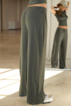 Side view of model from the waist down posing in the relaxed fit spruce modal Relaxed Straight Leg Pant with a wide leg, elastic waistband, adjustable drawstring tie and subtle pleating at the sides.