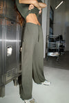 Side view of model from the waist down posing in the relaxed fit spruce modal Relaxed Straight Leg Pant with a wide leg, elastic waistband, adjustable drawstring tie and subtle pleating at the sides.