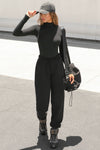 Full body front view of model posing in the form fitting stretchy vintage black rib Classic Turtleneck long sleeve top