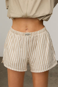 Close up front view of model from the waist down posing in the tobacco stripe classic cotton boxer-inspired Boxer Short in a relaxed silhouette, with an elastic waistband and side pockets.