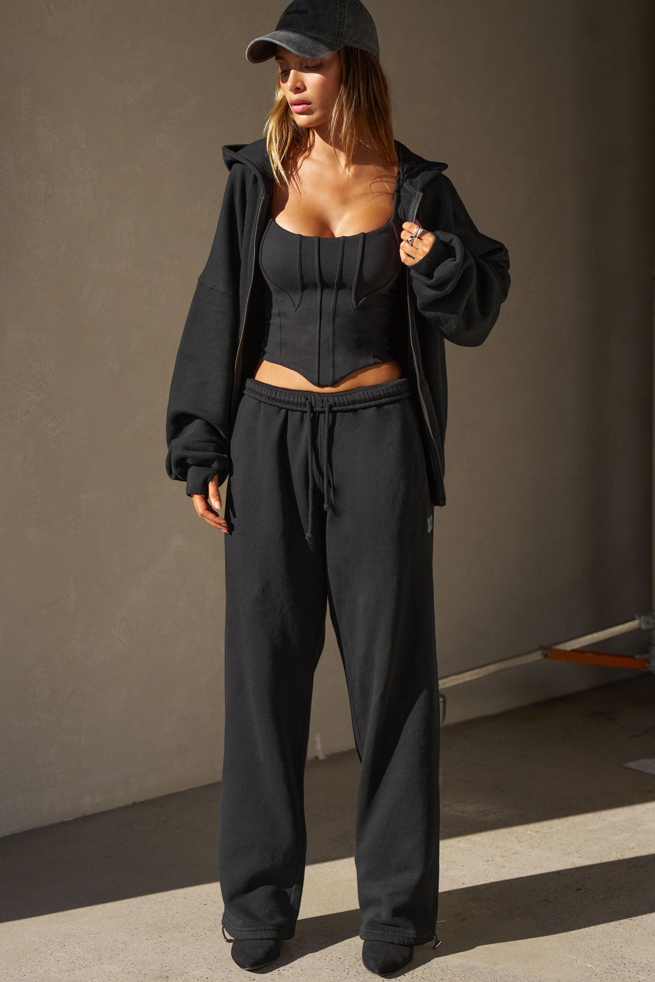 Full body front view of model posing in the fitted sueded onyx Contour Corset Tank with contour seaming, curved front hem and adjustable straps.