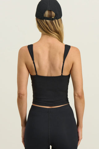 Back view of model posing in the fitted sueded onyx Contour Corset Tank with contour seaming, curved front hem and adjustable straps.