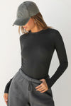 Front view of model posing in the fitted and stretchy vintage black rib Crewneck Long Sleeve with a banded crew neckline